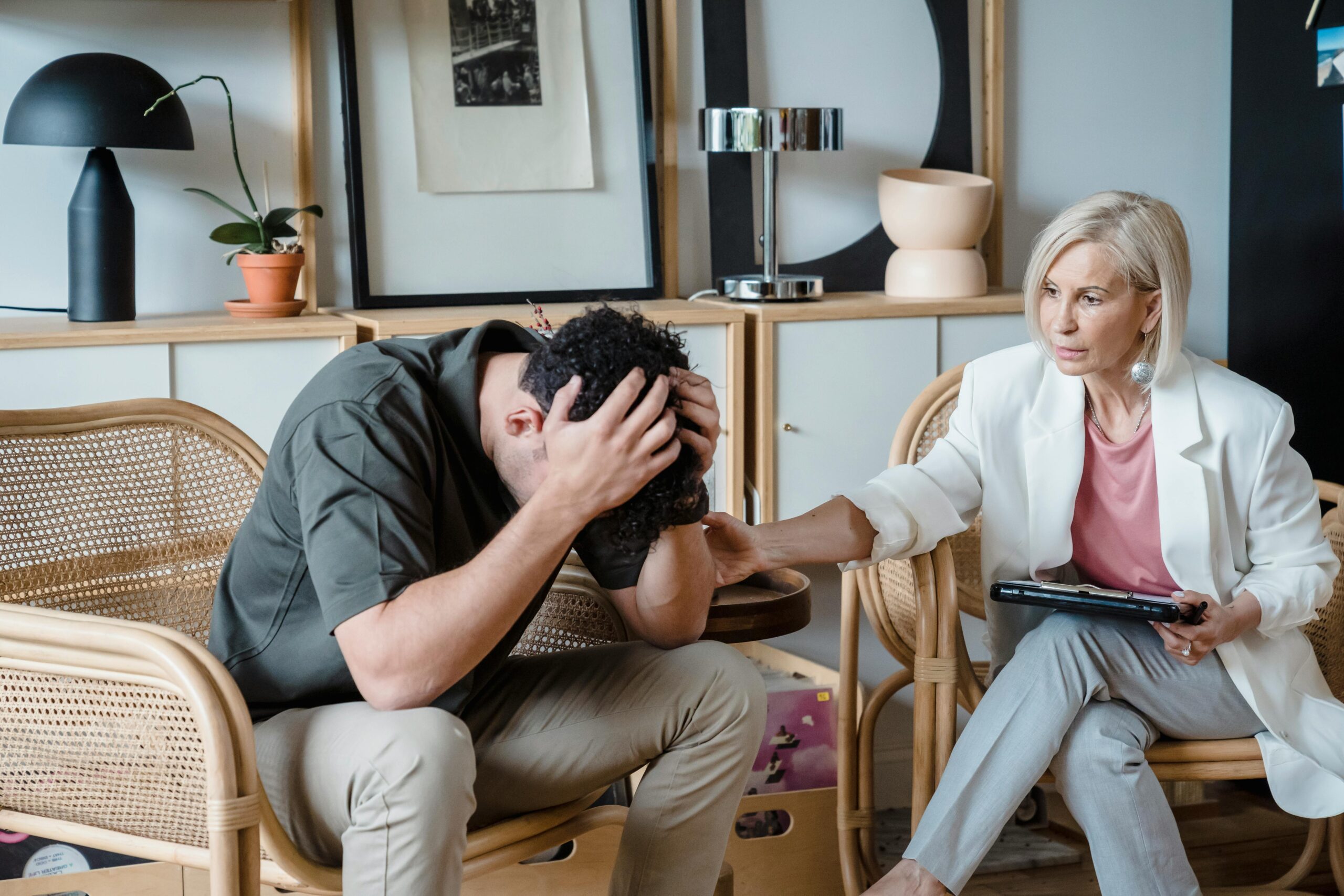 A supportive therapist provides comfort during a counseling session in a cozy office.